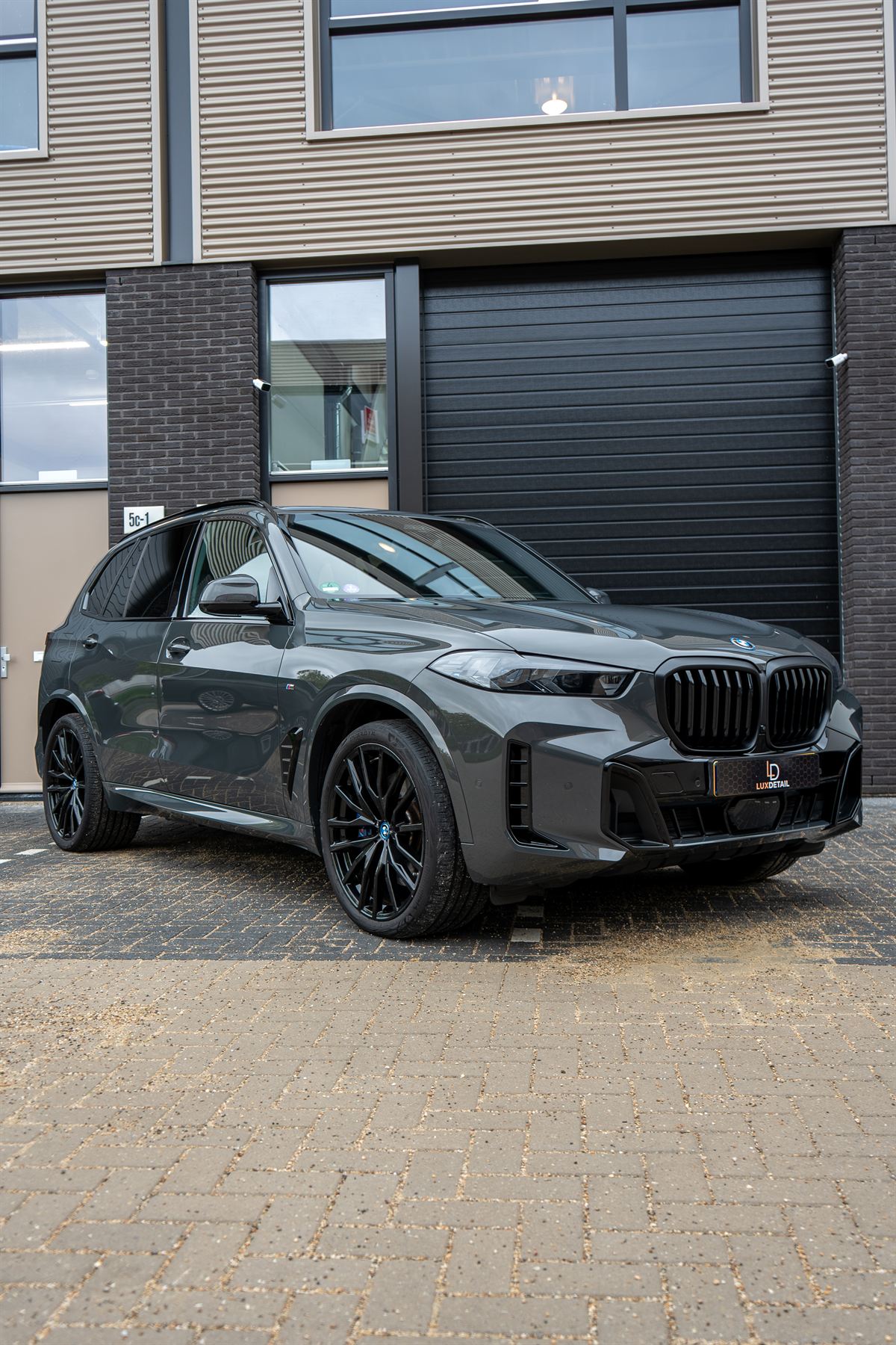 Grijze BMW X5, schuin van voren
